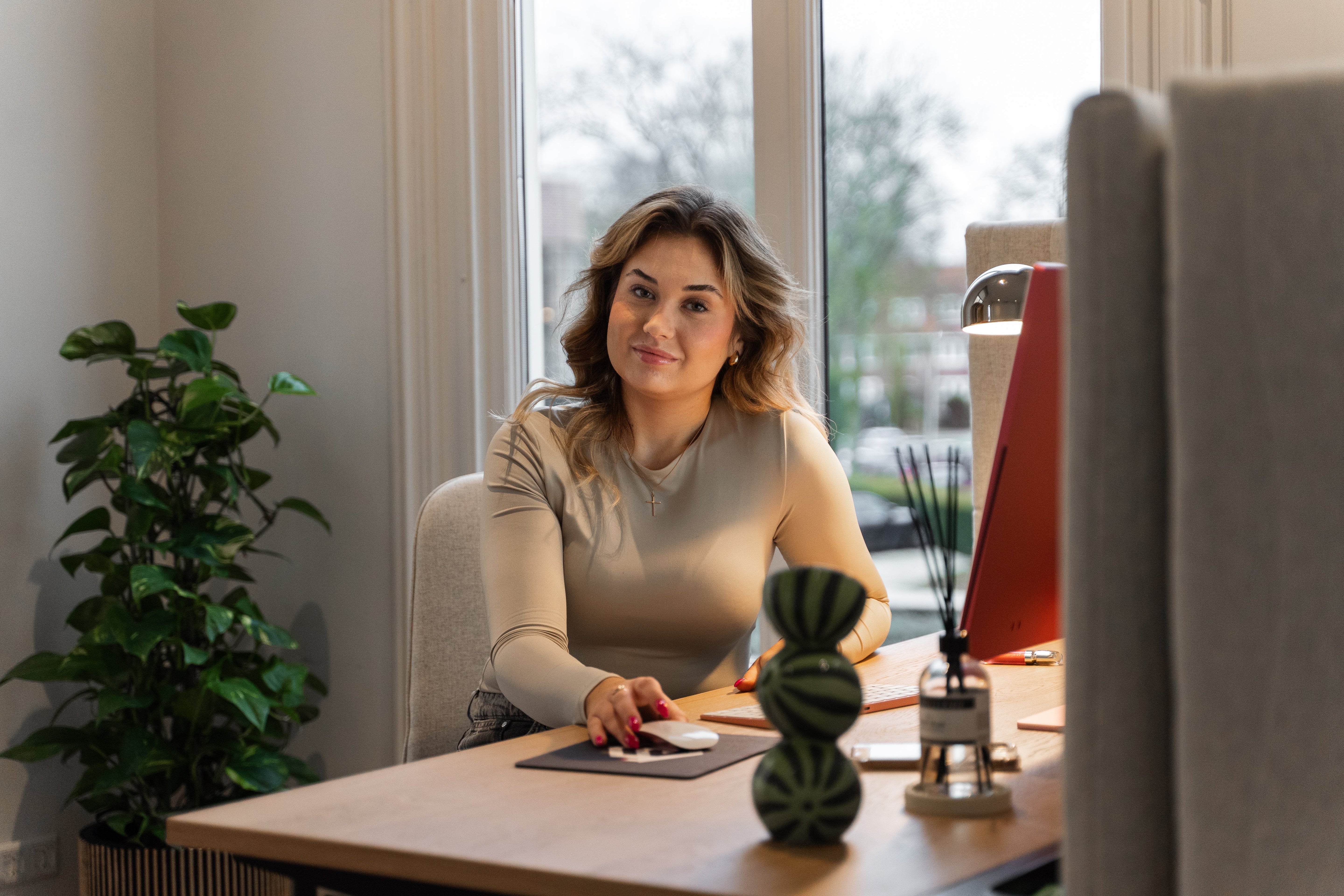 Student zit geconcentreerd aan een bureau met een computer, bezig met haar examenvoorbereiding met behulp van ExamBooks.